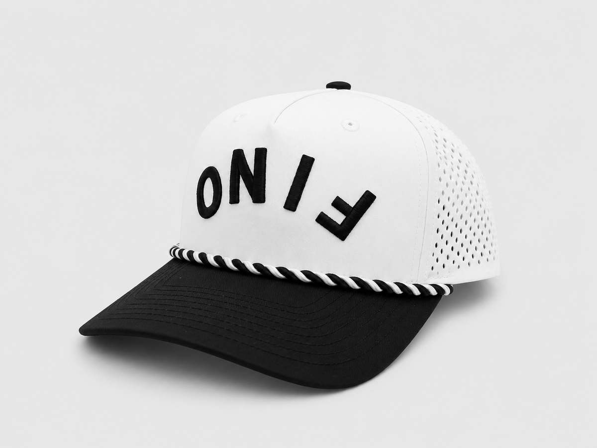 Three-quarter view of the white and black Fino cap with upside-down lettering and perforated side panels.