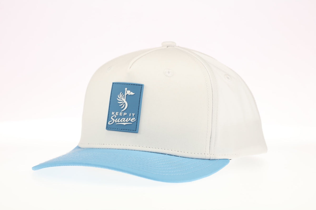 Keep It Suave snapback with cream crown, baby-blue brim, and blue logo patch, three-quarter view.