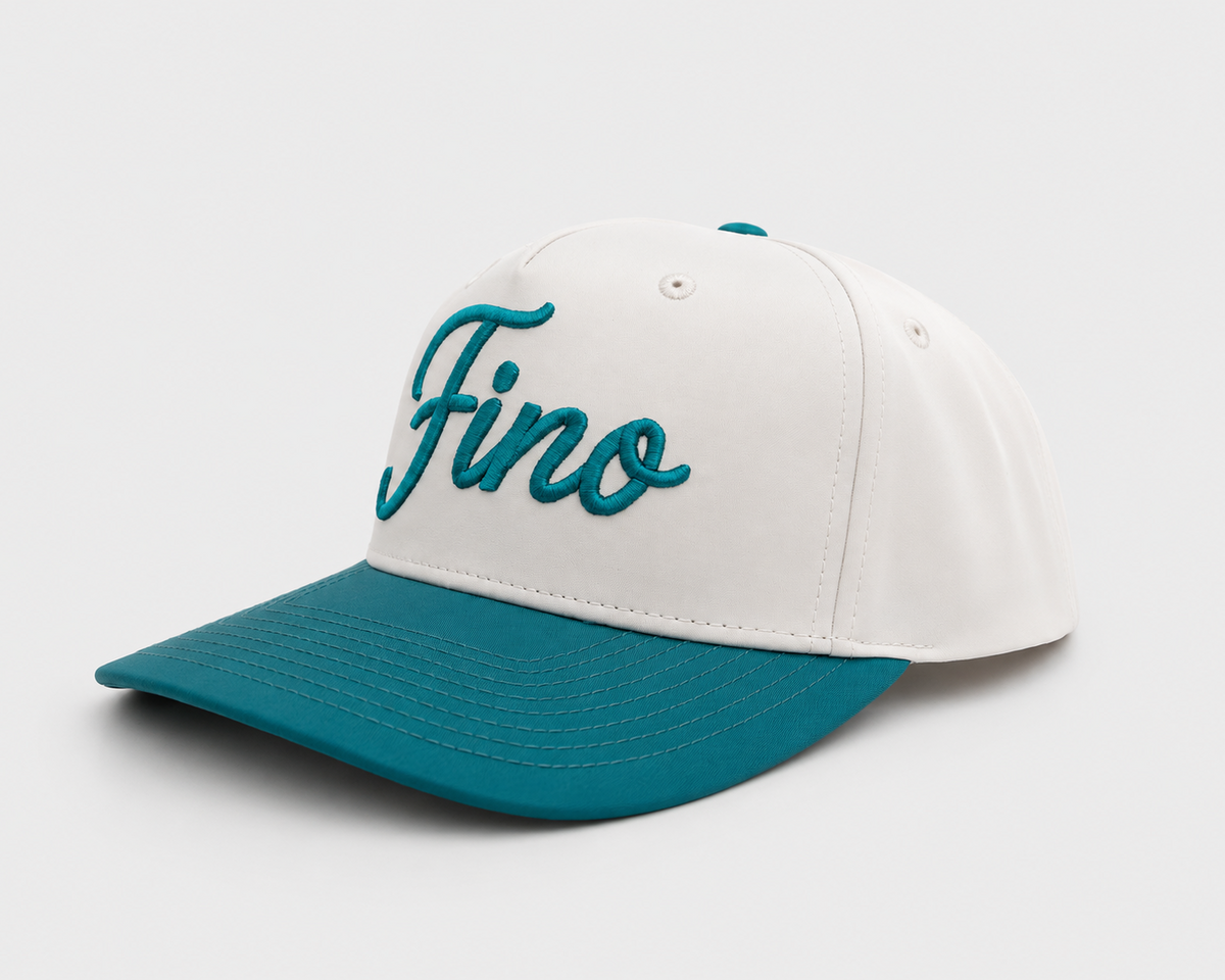 Three-quarter view of the white and teal Fino snapback with teal script embroidery and a teal brim.