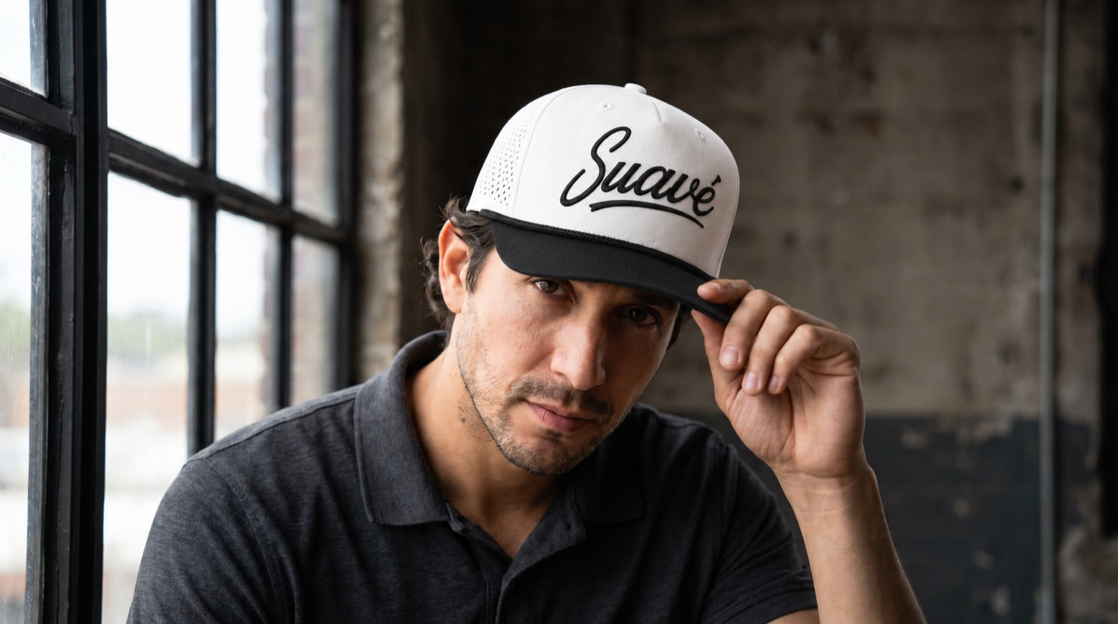 Golfer tipping the brim of a white and black Suave hat